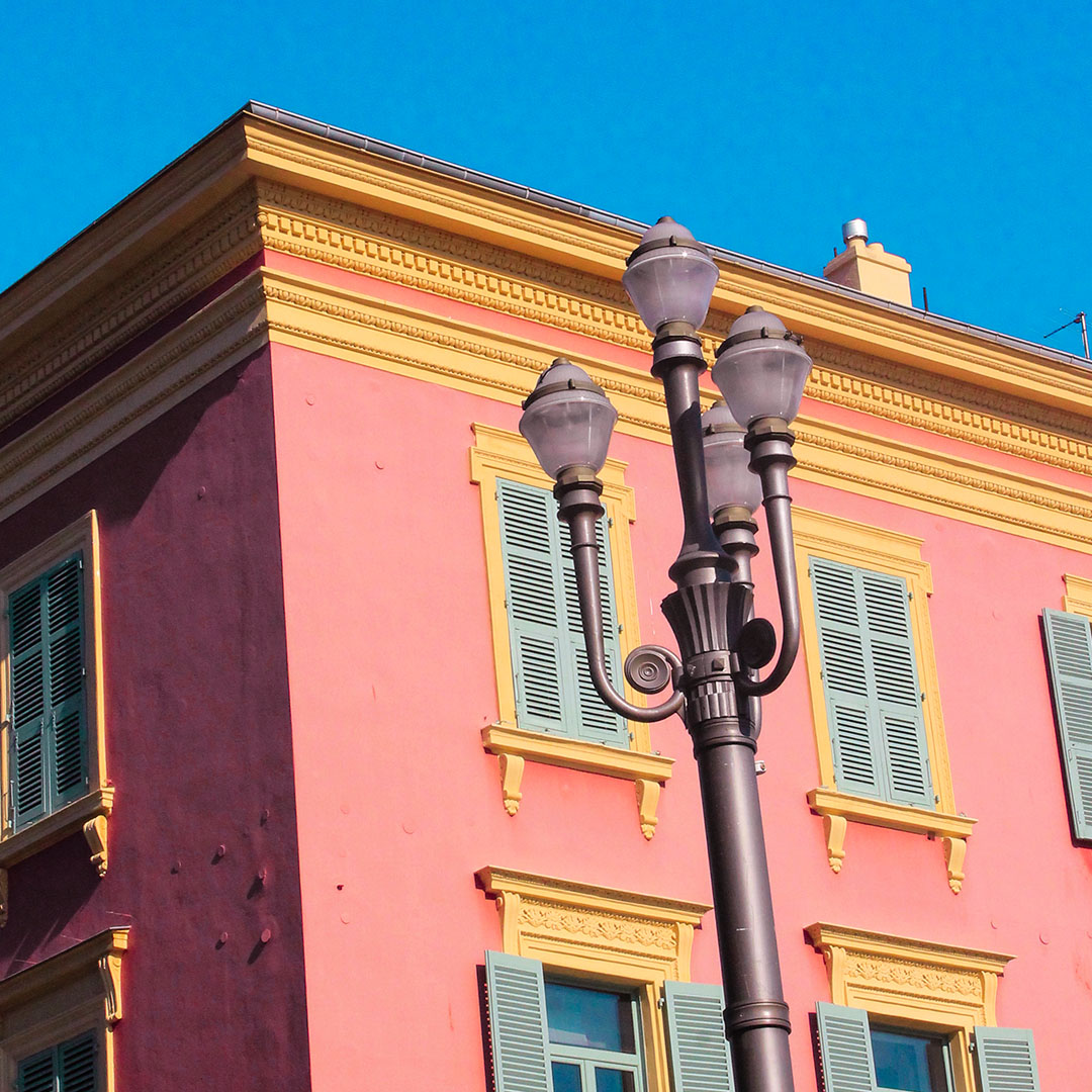 Pink and yellow building against blue sky in Nice, France